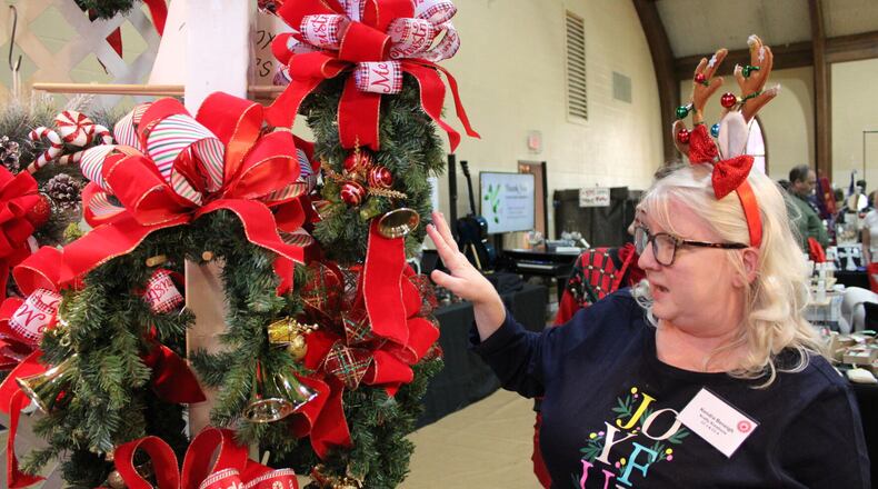 Kendra Beneigh, co-owner of Krafty Kreations, showcases her mother Karen’s decorative mailbox covers at the 43rd Annual Apple Annie Arts and Crafts Show Friday.