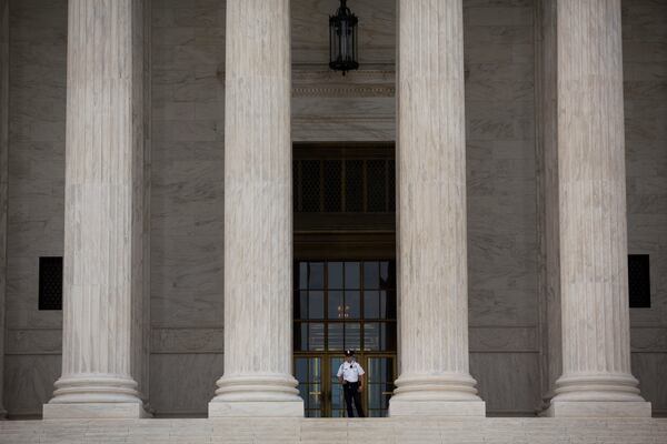 A Supreme Court Police officer stands at the top of the steps at the Supreme Court in Washington, D.C., U.S., on Monday, June 22, 2015. The U.S. Supreme Court is poised to issue blockbuster rulings on same-sex marriage and health care with both rulings due by the end of June as the court finishes its nine-month term with its traditional flurry of major opinions. Photographer: Drew Angerer/Bloomberg