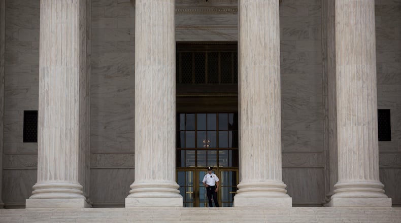 A Supreme Court Police officer stands at the top of the steps at the Supreme Court in Washington, D.C., U.S., on Monday, June 22, 2015. The U.S. Supreme Court is poised to issue blockbuster rulings on same-sex marriage and health care with both rulings due by the end of June as the court finishes its nine-month term with its traditional flurry of major opinions. Photographer: Drew Angerer/Bloomberg