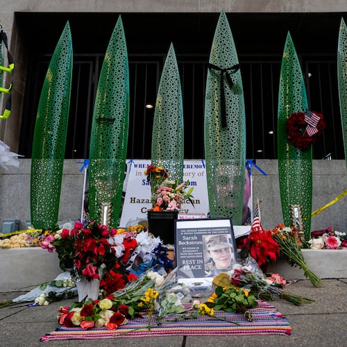 A makeshift memorial for U.S. Army Spc. Sarah Beckstrom and U.S. Air Force Staff Sgt. Andrew Wolfe is seen outside of Farragut West Station, near the site where the two National Guard members were shot, Monday, Dec. 1, 2025, in Washington. (AP Photo/Julia Demaree Nikhinson)