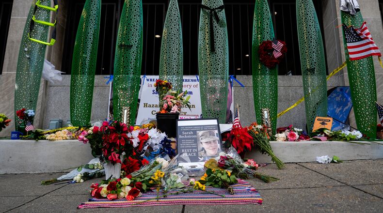 A makeshift memorial for U.S. Army Spc. Sarah Beckstrom and U.S. Air Force Staff Sgt. Andrew Wolfe is seen outside of Farragut West Station, near the site where the two National Guard members were shot, Monday, Dec. 1, 2025, in Washington. (AP Photo/Julia Demaree Nikhinson)