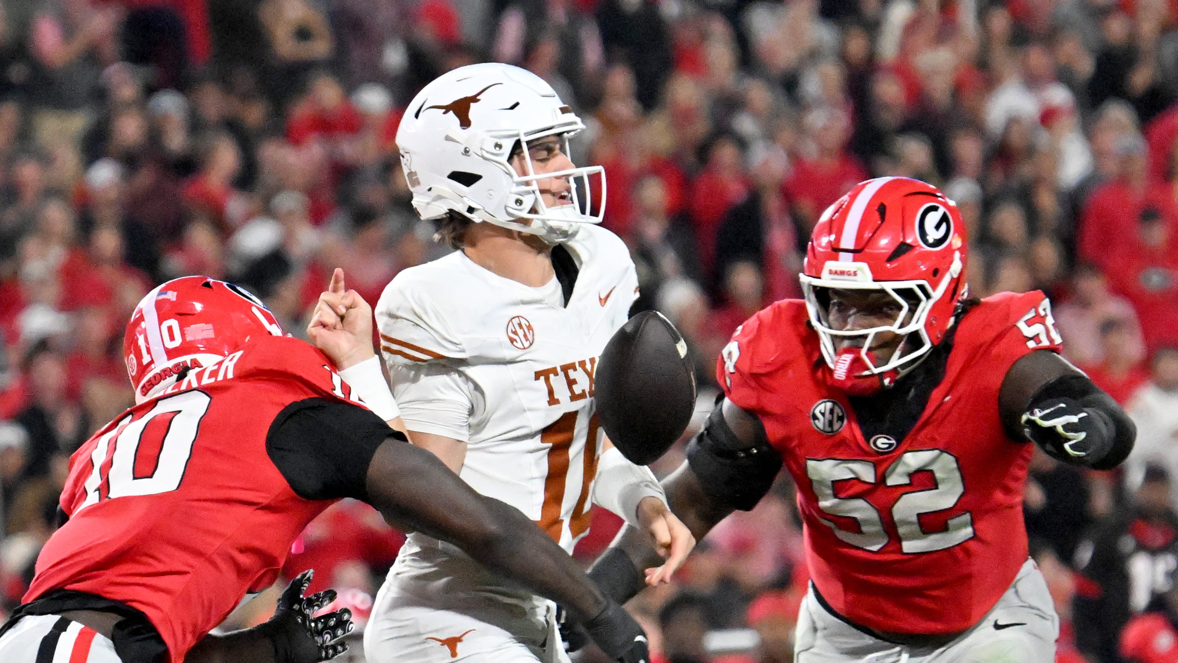 Georgia linebacker Zayden Walker (left) hits Texas quarterback Arch Manning (center), causing a fumble during the second half Saturday, Nov. 15, 2025, at Sanford Stadium in Athens. The Longhorns recovered the fumble. (Hyosub Shin/AJC)