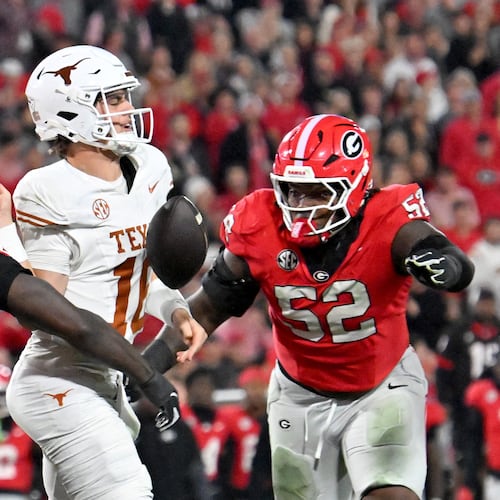 Georgia linebacker Zayden Walker (left) hits Texas quarterback Arch Manning (center), causing a fumble during the second half Saturday, Nov. 15, 2025, at Sanford Stadium in Athens. The Longhorns recovered the fumble. (Hyosub Shin/AJC)
