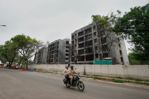 Policemen ride past buildings damaged in the June 12 Air India plane crash in Ahmedabad, India, Saturday, July 12, 2025. (AP Photo/Ajit Solanki)