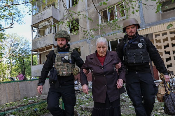 Police officers evacuate a woman from a multi-storey building damaged by a Russian strike on residential neighbourhood in Zaporizhzhia, Ukraine, on Tuesday, April 22, 2025. (AP Photo/Kateryna Klochko)