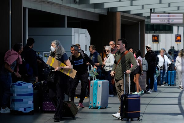 Travelers arrive at San Francisco International Airport ahead of the Memorial Day holiday weekend in San Francisco, Thursday, May 22, 2025. (AP Photo/Godofredo A. Vásquez)
