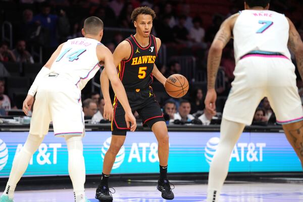 Atlanta Hawks guard Dyson Daniels (5) looks for a passing lane as Miami Heat guard Tyler Herro (14) and center Kel'el Ware (7) defend during the first half of an NBA basketball game, Thursday, March 27, 2025, in Miami. (AP Photo/Jim Rassol)