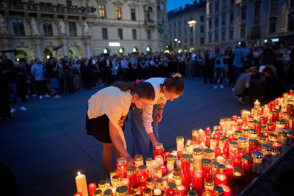 People light candles for victims of a former student who opened fire at a school, fatally wounding 10 people and injuring many others before taking his own life, in Graz, Austria, Tuesday, June 10, 2025. (AP Photo/Darko Bandic)