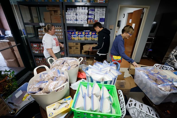 Teresa Acosta (left) food pantry coordinator for the Latin American Association, works with volunteers Nick Nele (center) and Ellen Levitt on Monday, Nov. 24, 2025, to move boxes after receiving donations from the Atlanta Community Food Bank and Bank of America. (Miguel Martinez/AJC)