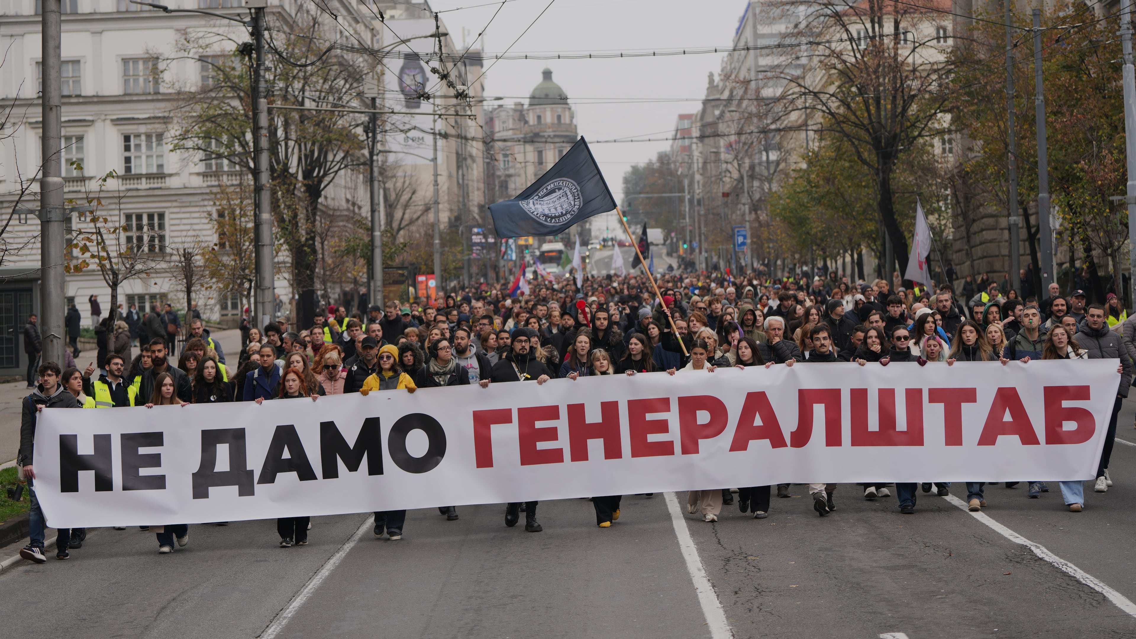 People hold a banner that reads: "We do not give army headquarters" during a protest in front of a military complex that was partially destroyed in a NATO bombing campaign in 1999, after Serbian lawmakers on Friday passed a special law clearing the way for a controversial real estate project that would be financed by an investment company linked to President Trump's son-in-law Jared Kushner, in Belgrade, Serbia, Tuesday, Nov. 11, 2025. (AP Photo/Darko Vojinovic)
