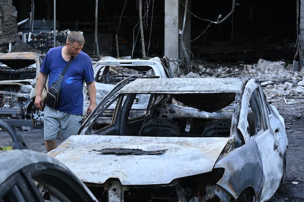 A resident looks at damaged cars at a residential area following Russia's drone attack in Odesa, Ukraine, Tuesday, July 22, 2025. (AP Photo/Michael Shtekel)