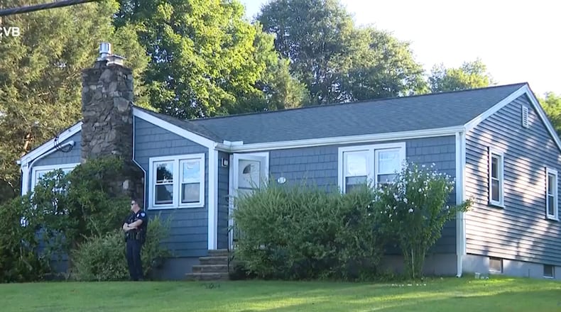 This screen grab made from video provided by WCVB-TV shows a police officer standing guard over a home in Worcester, Mass., Tuesday, Aug. 18, 2026. (WCVB-TV via AP)