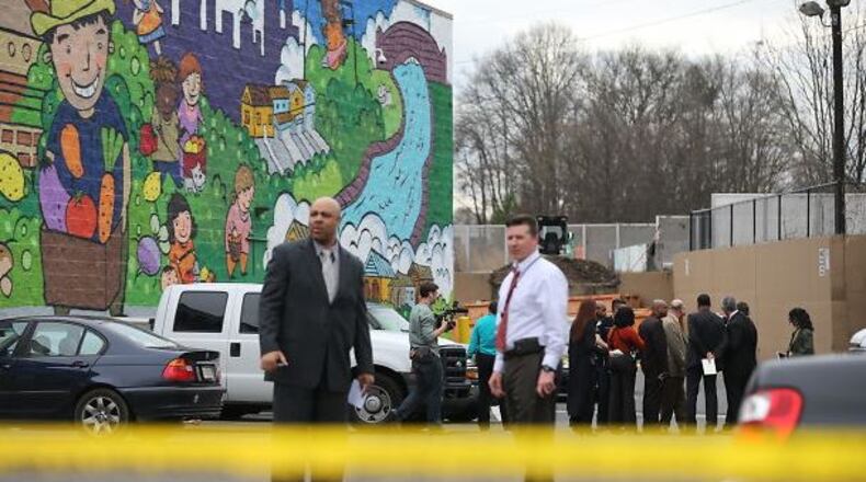 Police investigate the scene of a fatal shooting in the parking lot of a Kroger on Ponce. BEN GRAY/BGRAY@AJC.COM
