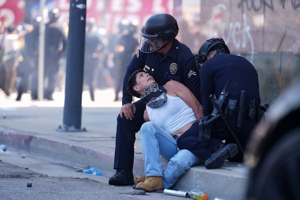 A protestor is detained in downtown Los Angeles, Sunday, June 8, 2025, following last night's immigration raid protest. (AP Photo/Eric Thayer)
