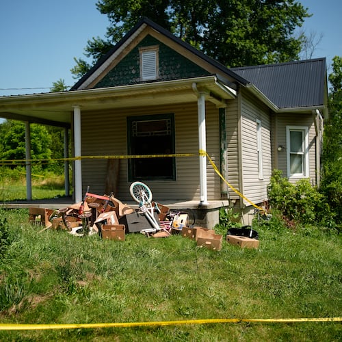 Police tape surrounds a home where authorities say they removed 16 children and arrested four adults in Hamden, Ohio, Wednesday, July 1, 2026. (AP Photo/Carolyn Kaster)