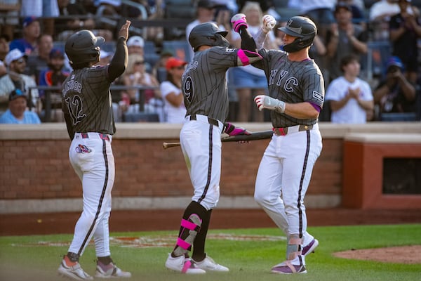 New York Mets' Pete Alonso, right, celebrates after his three-run home run with Francisco Lindor (12) and Brandon Nimmo (9) during the seventh inning of a baseball game against the New York Yankees, Saturday, July 5, 2025, in New York. (AP Photo/Angelina Katsanis)