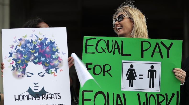 Elana Goodman joins with other protesters calling for women to be paid equally to their male co-workers on March 14, 2017 in Fort Lauderdale, Fla. A report released Wednesday found many women professors are paid less than their male counterparts.