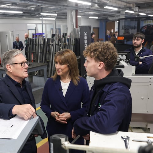 Britain's Prime Minister Keir Starmer, left, talks with a student, next to Britain's Chancellor of the Exchequer, Rachel Reeves, center, at the engineering workshop at Coleg Menai, during his visit to announce Wylfa on Anglesey, an island in North Wales, as the location for the country's first small modular reactor in Llangefni, North Wales, Britain, Thursday, Nov. 13, 2025. (Temilade Adelaja/Pool Photo via AP)