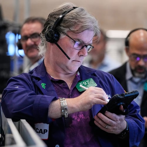 Options trader Brian Garvey, left, works on the floor of the New York Stock Exchange, Monday, Oct. 20, 2025. (AP Photo/Richard Drew)
