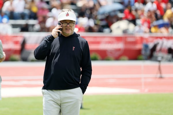 Georgia football coach Kirby Smart, making a call or two at the recent state high school track meet in Athens. (Miguel Martinez/AJC)