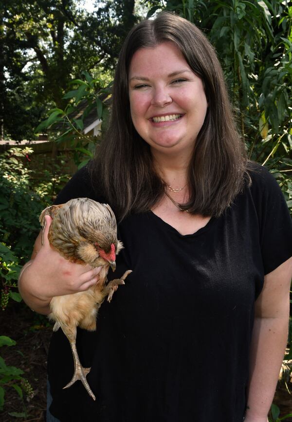 Taylor Mead, market manager at the Ponce City Farmers Market, holds her favorite egg-laying hen, Alice, who was named after Mead's grandmother. Taylor and her husband, who live in Atlanta, consider themselves "urban homesteaders." (Chris Hunt for the AJC)