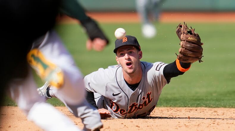 Detroit Tigers shortstop Zack Short flips the ball toward second base on an infield single hit by Oakland Athletics' Esteury Ruiz during the eighth inning of a baseball game in Oakland, Calif., Saturday, Sept. 23, 2023. (AP Photo/Jeff Chiu)