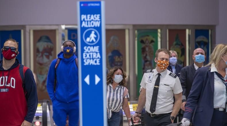 Masked airline passengers arrive at Hartsfield Jackson International Airport on May 20, 2020. (ALYSSA POINTER / ALYSSA.POINTER@AJC.COM)