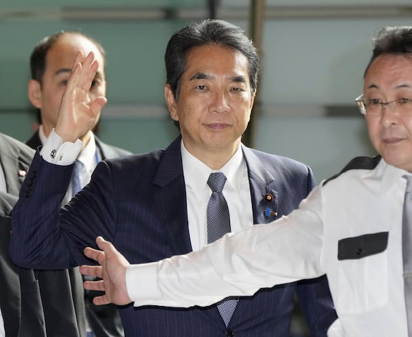 Japan's Agriculture Minister Taku Eto, center, arrives at the prime minister's office in Tokyo Wednesday, May 21, 2025. (Kyodo News via AP)