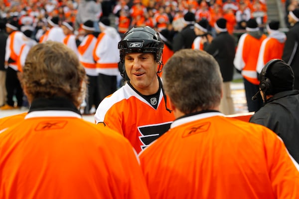 FILE - Rick Tocchet, of the Philadelphia Flyers Alumni team, greets fellow alumni as he walks to the rink during opening ceremonies for the Winter Classic Alumni hockey game with the New York Rangers Alumni team, Saturday, Dec. 31, 2011 in Philadelphia. (AP Photo/Tom Mihalek, file)