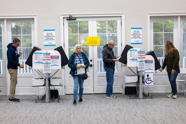 People use voting machines at the River Green Heritage Club, a polling place in Canton, back in January. (Arvin Temkar/AJC)