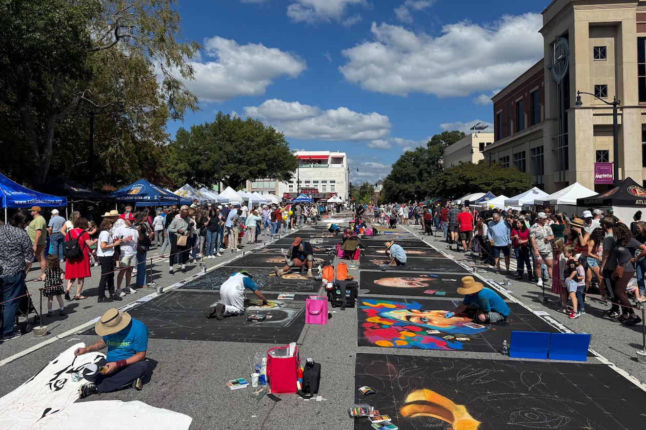 Professional artists work on their chalk drawings during Chalktoberfest on Saturday. (Caleb Groves/ AJC)