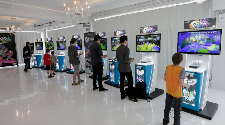Attendees play the new "Splatoon" video game on a Nintendo Co. Wii U console at a pre-launch event in New York, U.S., on Wednesday, May 6, 2015. Nintendo Co. is scheduled to release earnings figures on May 7. Photographer: Peter Foley/Bloomberg
