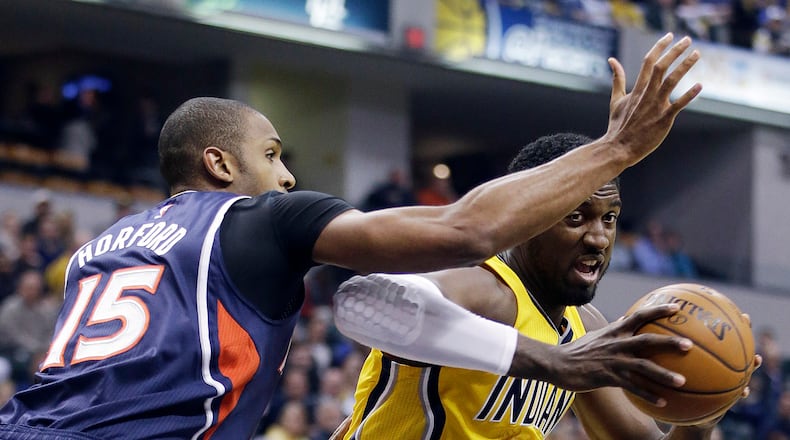 Indiana Pacers' Roy Hibbert (55) goes to the basket against Atlanta Hawks' Al Horford (15) during the first half of an NBA basketball game Monday, Dec. 8, 2014, in Indianapolis. (AP Photo/Darron Cummings)