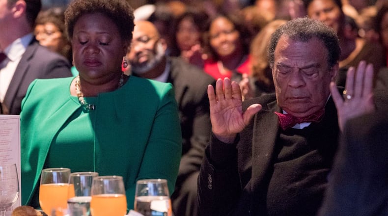 Fomer Atlanta mayor Andrew Young and City Council President-elect Felicia Moore bow their heads at a pre-inaugural event last January. ALYSSA POINTER/ALYSSA.POINTER@AJC.COM