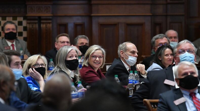 Republican state Rep. Bonnie Rich of Suwanee, center, smiles as she and other lawmakers vote on the Georgia House map for redistricting. The Senate approved the map on Friday. (Hyosub Shin / Hyosub.Shin@ajc.com)