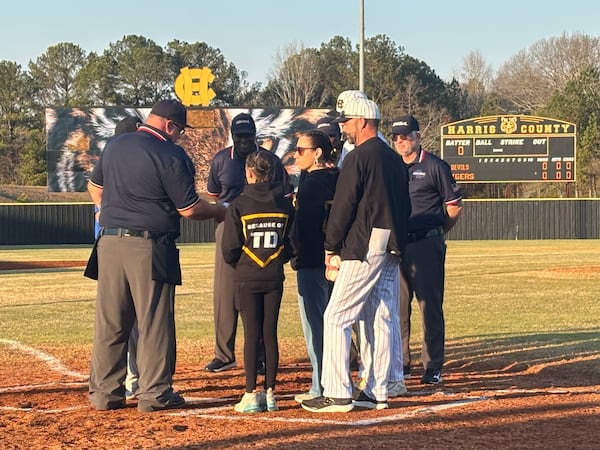 Family members of Harris County baseball coach Tony Dimitri, who died Jan. 24, brought the lineup card out to home plate before Harris County's season opener Monday, Feb. 9, 2026. (Jack Leo/AJC)