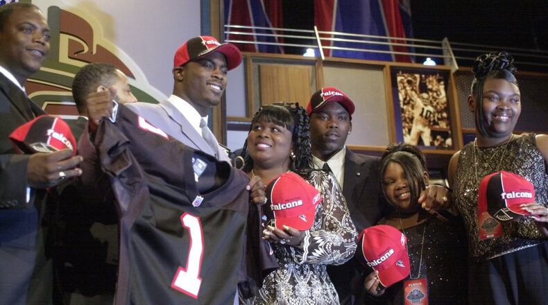 Quarterback Michael Vick, second from left, of Virginia Tech, holds up an Atlanta Falcons jersey after being selected as the No. 1 overall pick of the NFL draft in New York, Saturday, April 21, 2001 in New York. Vick is joined by his mother, Brenda Boddie, center, and unidentified members of his family. (AP Photo/Ed Betz)