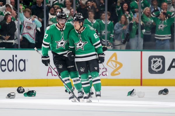 Dallas Stars' Mason Marchment (27) and Mikael Granlund, right, celebrate Granlund earning a hat trick in the third period of Game 4 of a second-round NHL hockey playoff series in Dallas, Tuesday, May 13, 2025. (AP Photo/Gareth Patterson)