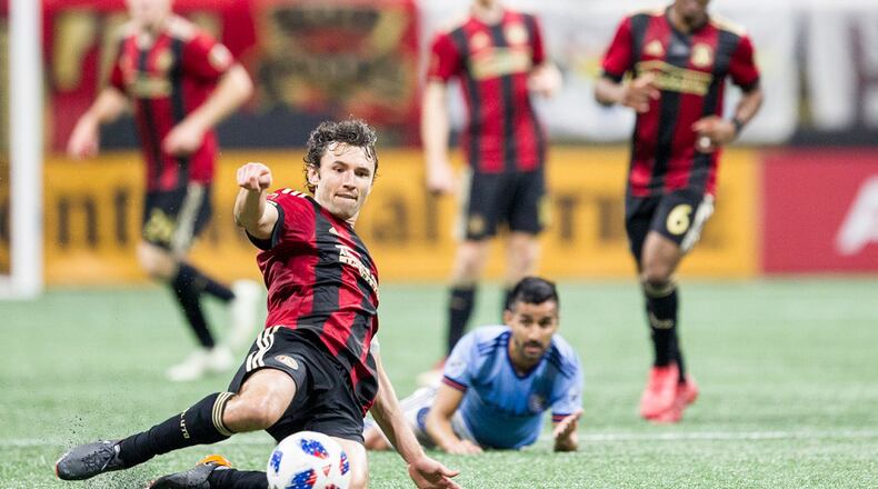 Atlanta United defender Michael Parkhurst (3) slides across the field to kick the ball during the match between NYC FC and Atlanta United at Mercedes-Benz Stadium in Atlanta, Georgia, on Sunday, April 15, 2018. (REANN HUBER/REANN.HUBER@AJC.COM)