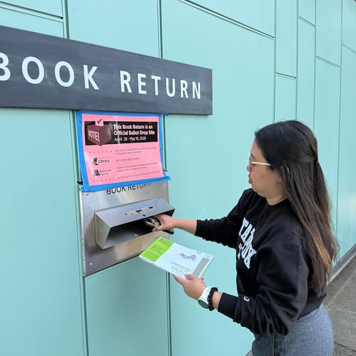 A voter drops off their ballot at a library in Portland, Ore. serving as a ballot dropbox site as Oregon held primary elections on May 19, 2026. (AP Photo/Claire Rush)