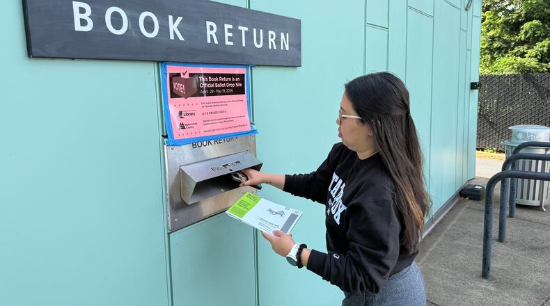 A voter drops off their ballot at a library in Portland, Ore. serving as a ballot dropbox site as Oregon held primary elections on May 19, 2026. (AP Photo/Claire Rush)