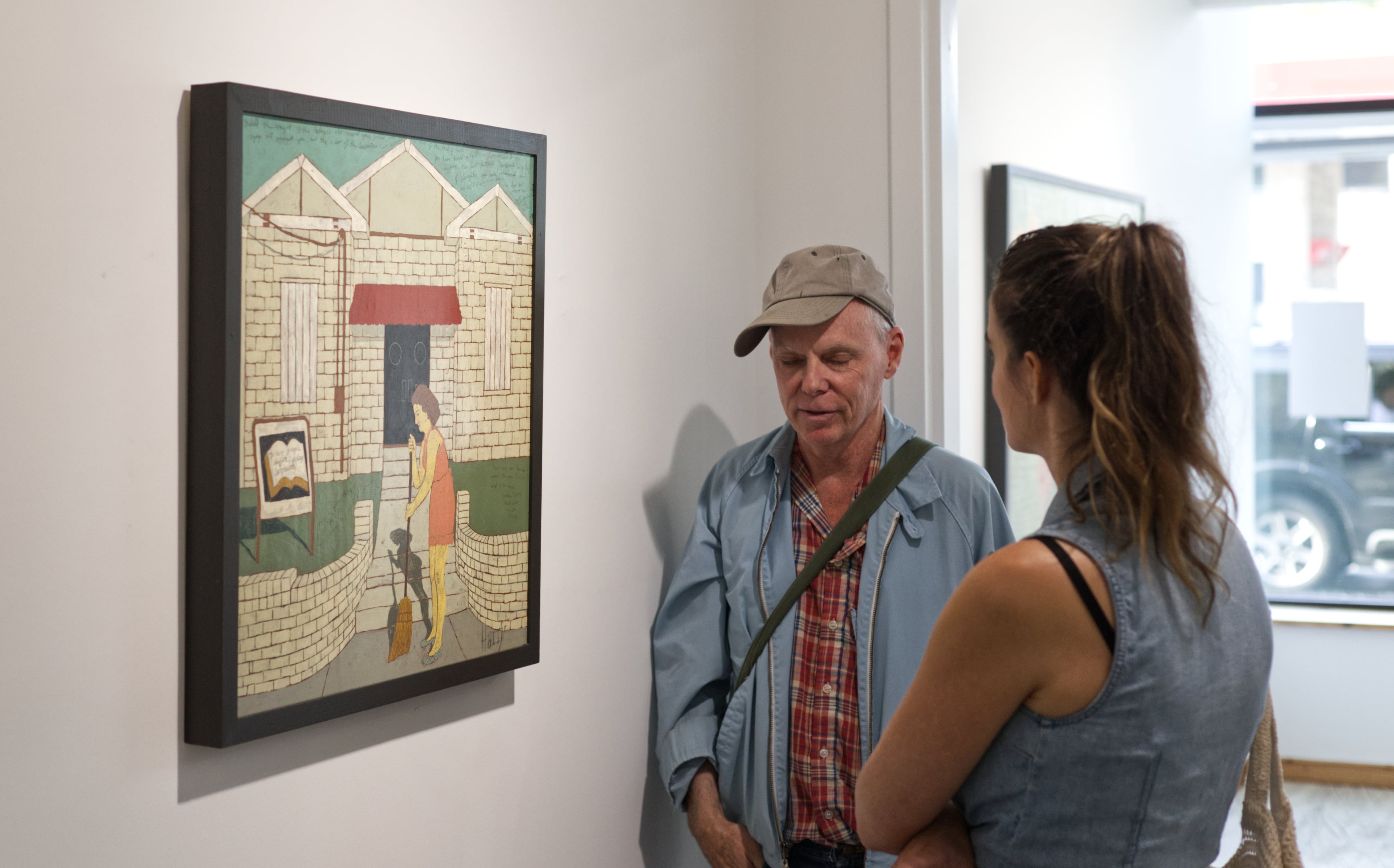 Starting by collaging covers for his music tapes, Harry Underwood (left) eventually took up painting and drawing, to which he added hand-scripted writing. “That kind of took me the direction that Finster did," the artist said, "to have words and pictures.” Far left, his painting "When People Suffer Delay is Cruelty" (2024). (Photo by Dustin Timbrook)
