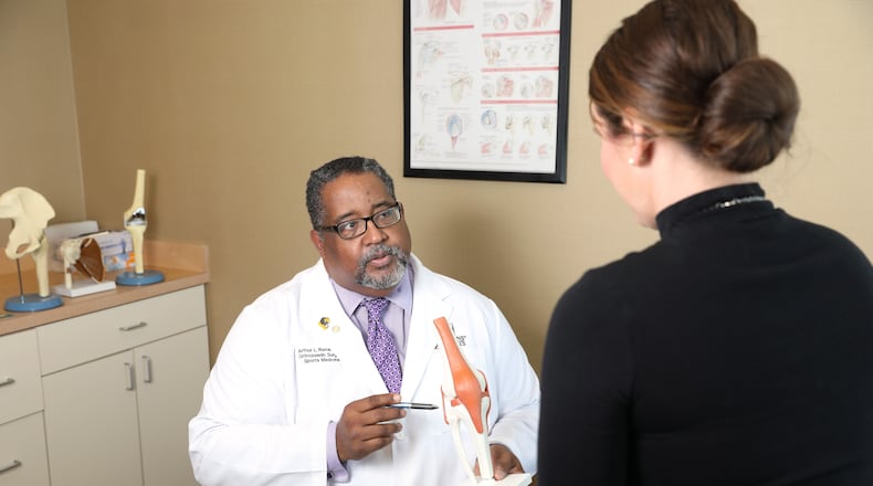Dr. Art Raines talks with a patient at the Emory University Hospital Midtown Thursday, October 11, 2018. Dr. Raines says that black doctors are more sensitive tot he needs of black patients. (JASON GETZ/SPECIAL TO THE AJC)