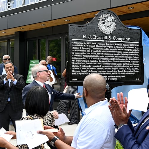 W. Todd Groce (left), president and CEO of the Georgia Historical Society, and Michael B. Russell Sr., CEO of H.J. Russell & Co, unveil a marker commemorating the company’s original headquarters April 29, 2026. (Hyosub Shin/AJC)