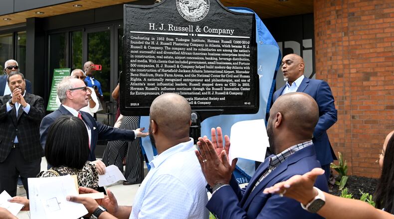 W. Todd Groce (left), president and CEO of the Georgia Historical Society, and Michael B. Russell Sr., CEO of H.J. Russell & Co, unveil a marker commemorating the company’s original headquarters April 29, 2026. (Hyosub Shin/AJC)