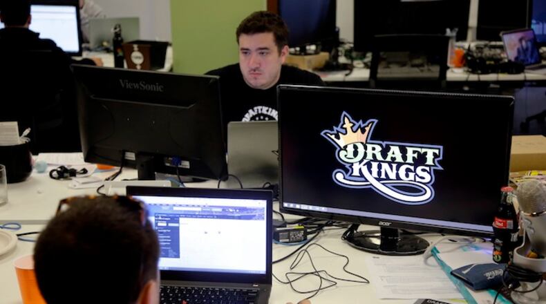In this Wednesday, Sept. 9, 2015, photo, Len Don Diego, marketing manager for content at DraftKings, a daily fantasy sports company, works at his station at the company's offices in Boston. The daily fantasy sports industry is eyeing a breakout season as NFL games begin. And its two dominant companies, DraftKings and FanDuel, are touting lucrative opening week prizes to try to draw more customers as more competitors pop up. (AP Photo/Stephan Savoia)