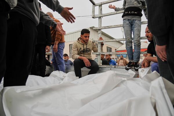 Mourners carry the bodies of three members of Dahouh family, killed when an Israeli army strike hit their tent, before their burial at the hospital in Deir al-Balah, Gaza Strip on Tuesday, April 1, 2025. (AP Photo/Abdel Kareem Hana)