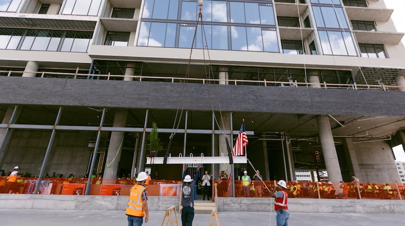 Crews lift a beam during the "topping out" ceremony for a 19-story apartment tower now called The Mitchell within the Centennial Yards development in downtown Atlanta. The ceremony on Thursday, Aug. 22, marked the tower reaching its highest point.