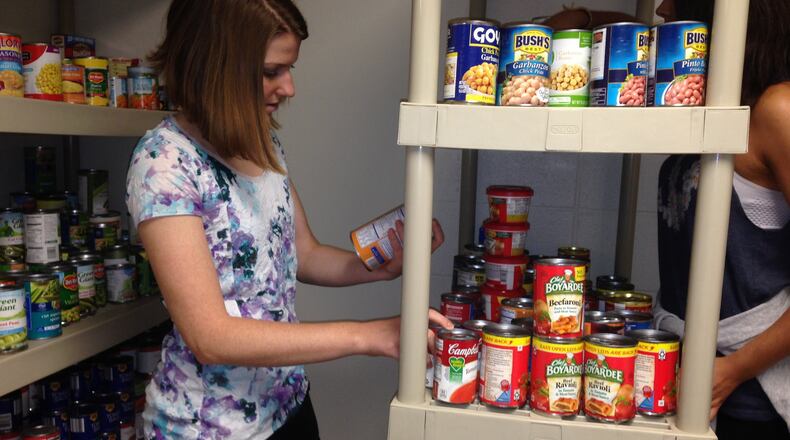 Georgia State University senior Diana Parker reads a label on a can of beans at the downtown campus’ new food pantry. Parker is one of the student volunteers at the pantry. Gracie Bonds Staples/gstaples@ajc.com