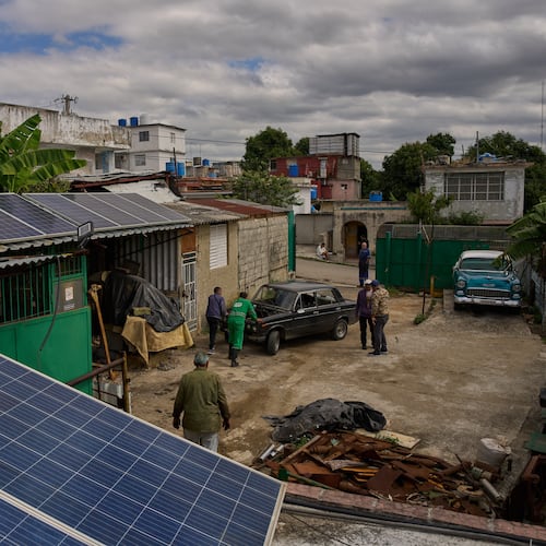 Solar panels cover the roof at the home of Felix Jose Morfi where mechanics push his broken down Lada car in Regla, Havana province, Cuba, Thursday, Jan. 29, 2026. (AP Photo/Ramon Espinosa)